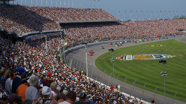 Cars approach a turn in front of huge grandstands during the Daytona 500