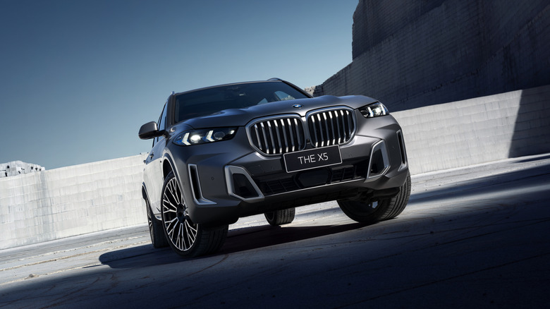 A BMW X5 is shown from an aggressively low angle.