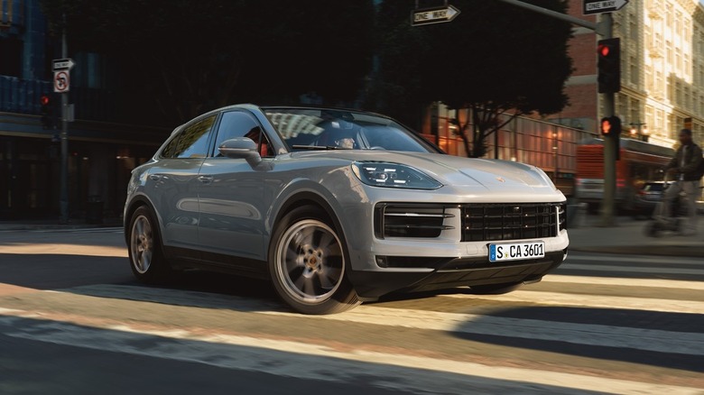 A gray Porsche Cayenne takes a turn in the city.