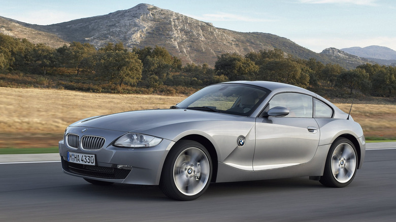 A silver Z4 coupe driving in front of a mountain