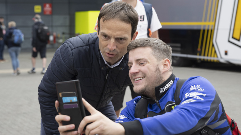 Sylvain Guintoli of France (ex rider) (L) poses in paddock with fan during the MotoGP Of Great Britain - Previews at Silverstone Circuit on May 22, 2025 in Northampton, England.