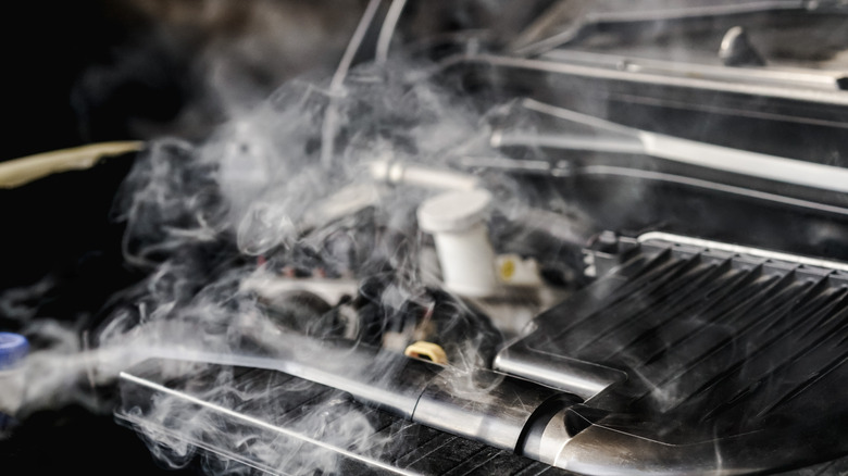 Smoke and steam emanating from an overheating car engine