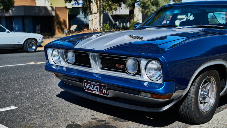 The front fascia of a deep metallic blue Ford Falcon XB GT sedan.