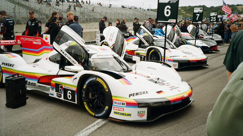 Two Apple livery Porsche 963s in the paddock at Laguna Seca