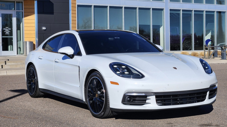 a white  2018 Porsche Panamera 4 parked in front of a car dealership