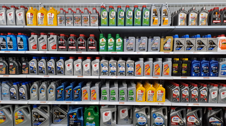 A selection of motor oil cans and bottles stocked on store shelves.