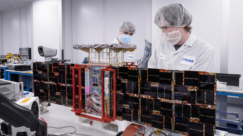 Dylan Schmidt, CAPSTONE assembly integration and test lead, right, and Lachlan Moore, systems integration engineer, left, install solar panels onto the CAPSTONE 01 spacecraft at Tyvak Nano-Satellite Systems, Inc., in Irvine, California.