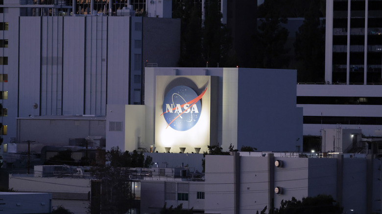 The NASA logo on the JPL facility lit up at night