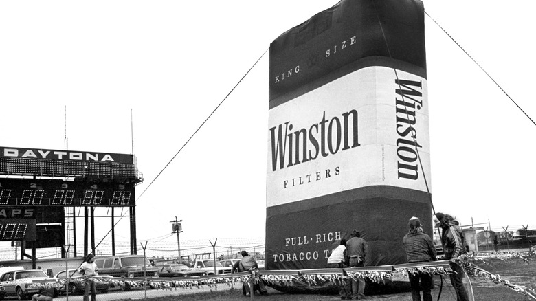 DAYTONA BEACH, FLORIDA - FEBRUARY 1980: Workers install an inflatable advetising balloon in the shape of a giant pack of Winston cigarettes in the speedway infield prior to the start of the 1980 Daytona 500 stock car race at Daytona International Speedway in Daytona Beach, Florida.