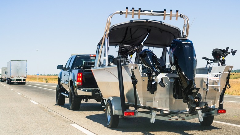 Pickup truck towing boat on a highway in the sunshine