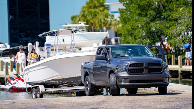 Ram truck towing boat on a trailer up boat ramp