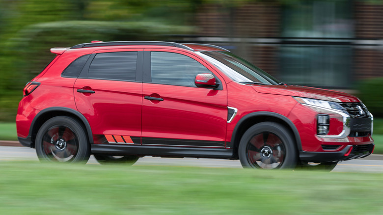 Mitsubishi Outlander Sport driving on a road next to a building