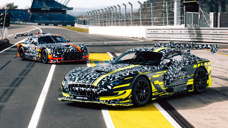 A camouflaged Mercedes-AMG GT Black Series in front of a GT3 race car