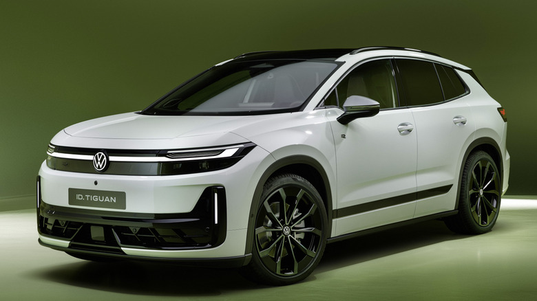 A front three-quarters shot of a white Euro-market ID. Tiguan R-Line parked in a green photo studio