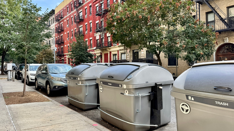 New York, NY USA - September 23, 2025 : Row of large, gray "Empire Bins" for residential building trash collection on W 151st Street in West Harlem, New York City