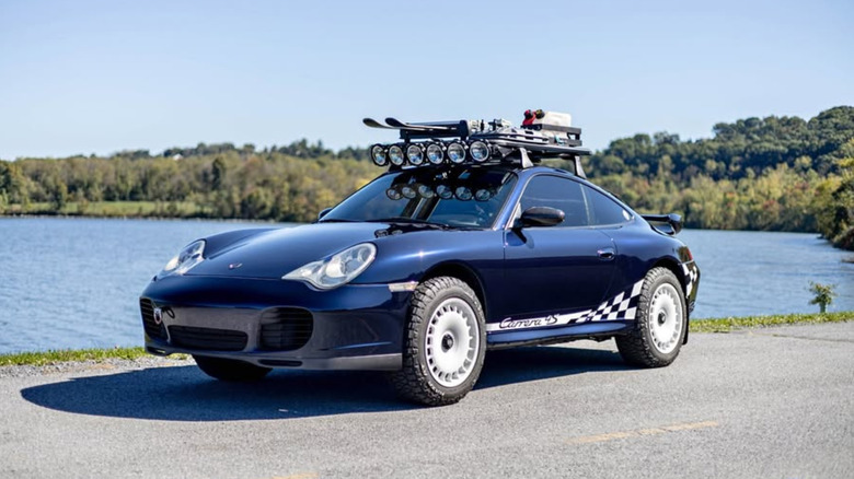 Blue Carrera 4S jacked up on rally wheels