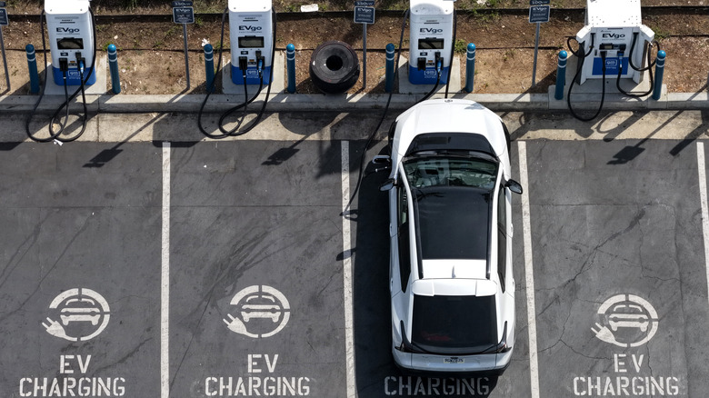 MONROVIA, CALIFORNIA - MARCH 30: In an aerial view, an electric vehicle charges at an EVgo electric charger on March 30, 2026, in Monrovia, California. As gas prices surge amid the war in Iran, online automotive resource Edmunds reported a 22% increase in searches for electric vehicles during the week of March 2, as motorists look for ways to avoid high fuel costs. (Photo by Justin Sullivan/Getty Images)