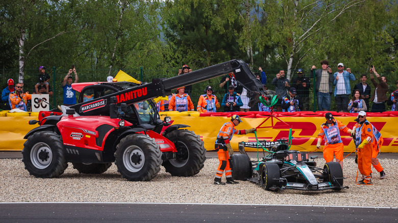 The (63) Mercedes W17 of George Russell of Great Britain and Mercedes AMG Petronas is lifted away from track following damage in the opening lap during the F1 Grand Prix of Belgium at Circuit de Spa-Francorchamps on July 19, 2026 in Spa, Belgium.