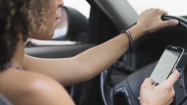 Woman looking at phone while driving
