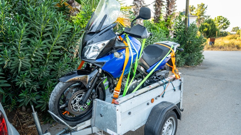 A motorcycle strapped down to a trailer