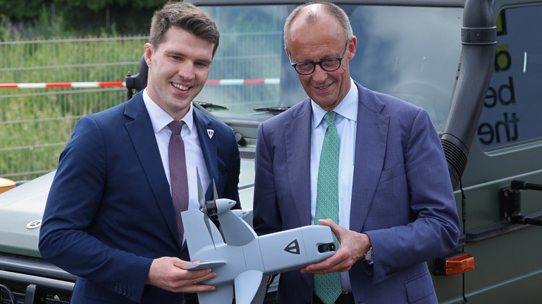 German Chancellor Friedrich Merz (R) and Tytan Technologies head Balazs Nagy hold a Tytan drone interceptor at the 2026 ILA Berlin Air Show On its opening day on June 10, 2026 in Schoenefeld, Germany