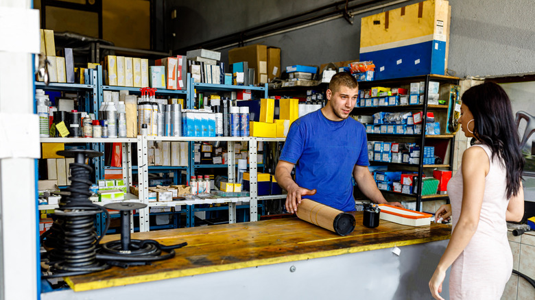 A customer asking car parts store clerk for auto parts