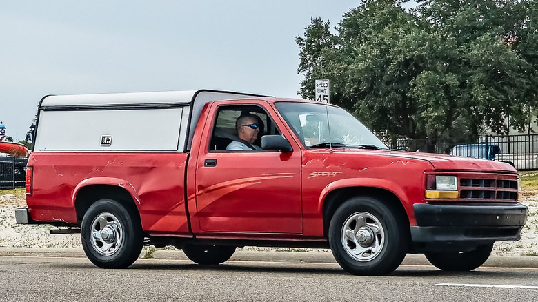 A red 1993 Dodge Dakota Sport pickup truck driving on the road