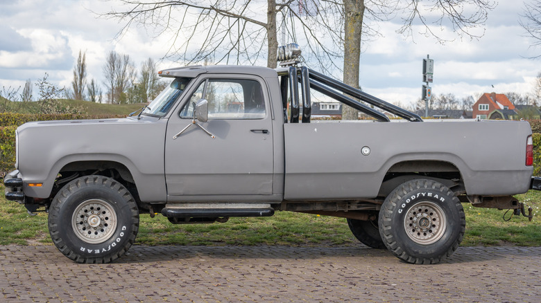A 1970s Dodge pickup truck with matte gray finish