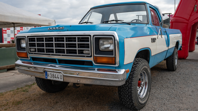 A two-tone white and blue first-generation Dodge Power Ram parked outside