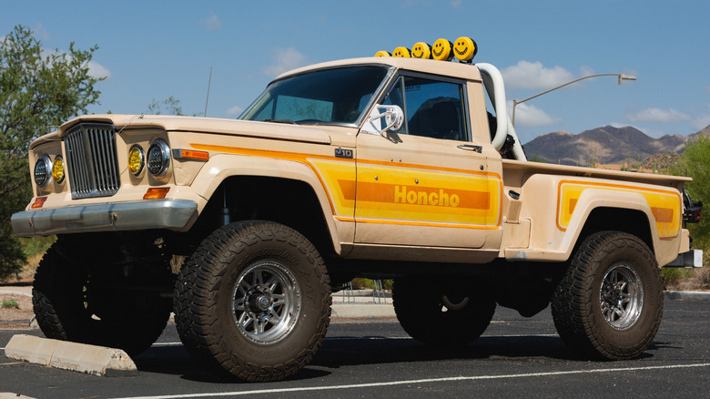 A tan and yellow 1970s Jeep J10 Honcho pickup truck in a parking lot