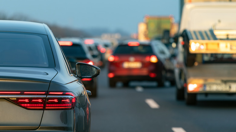 A blurred red estate car changing lanes on a busy highway.