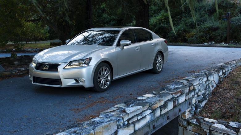 A Lexus GS on a small bridge amid trees.