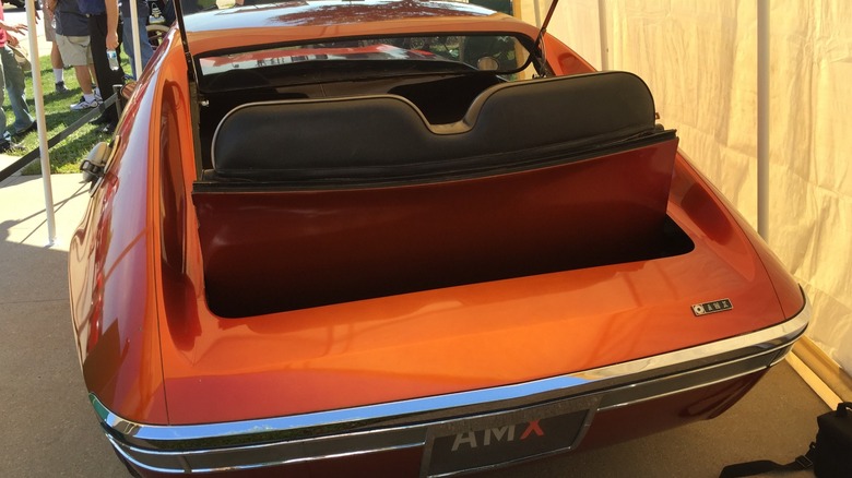 A rearview shot of a red-orange 1966 AMC AMX prototype showing the rear Rumble Seat