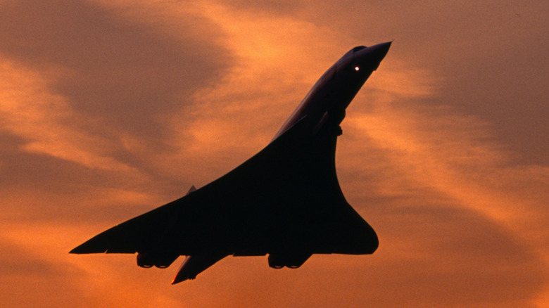 A Concorde taking off into an orange sky at sunset