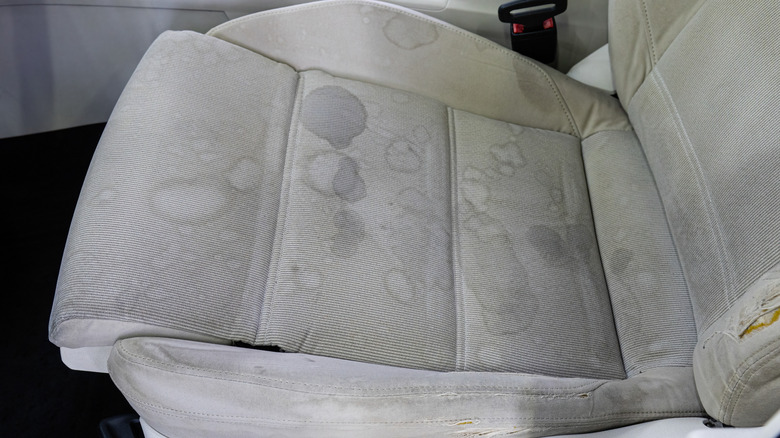 A dirty, stained gray cloth car seat