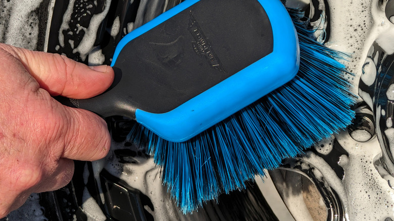 A Bowden's Own tire brush called The Chubby being used to clean a tire.