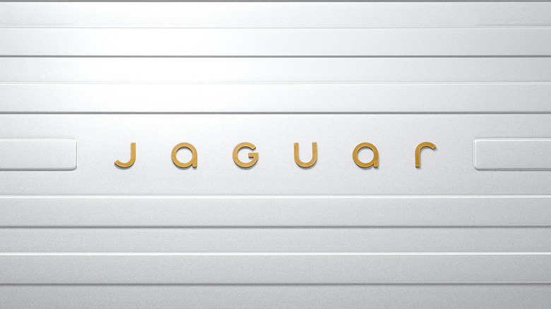 A white slatted-looking wall with a part in the middle that reads "jaguar" in its lowercase font in gold.