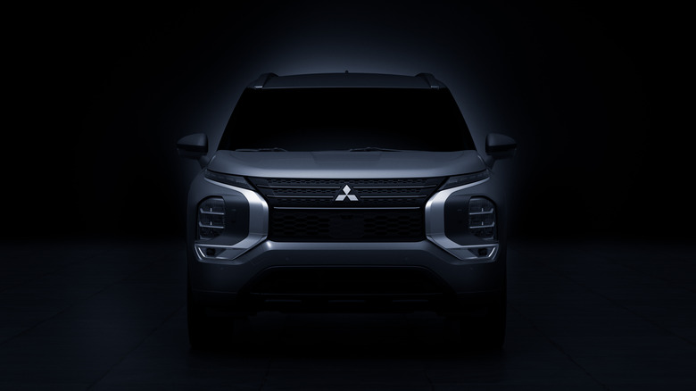 A shadowy-lit Mitsubishi Outlander in a black void.