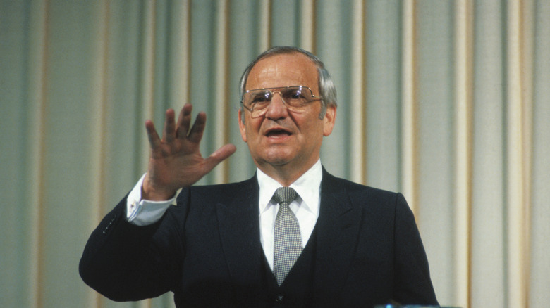 Lee Iacocca gestures with his hand while speaking