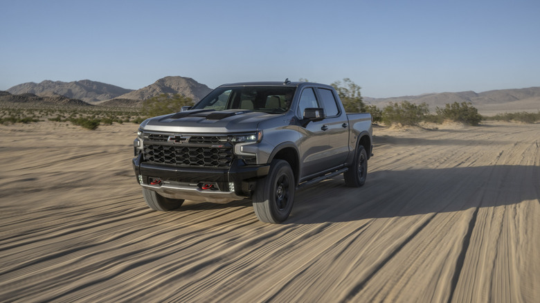 Front 3/4 view of a gray 2024 Chevy Silverado 1500 ZR2 driving through the desert