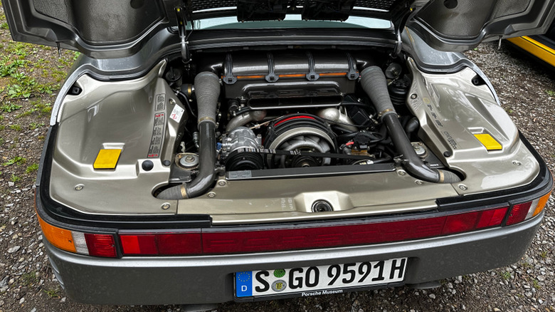 A Porsche 959 with its hood open, revealing the engine