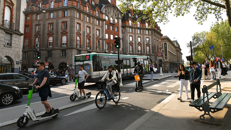 Cyclists, pedestrians and cars in a Paria street.