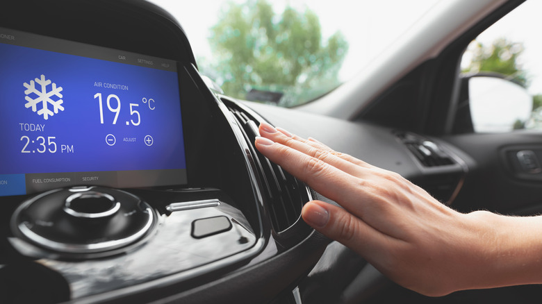 A hand testing the AC temperature in a car