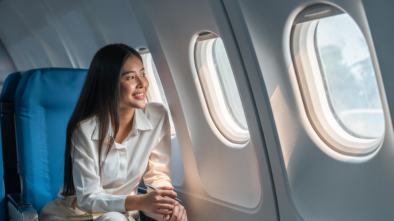 A woman enjoying a window seat that in fact has a window