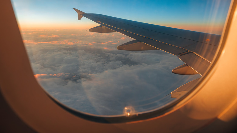 A view of a cloudy sky at dusk out the window of a plane
