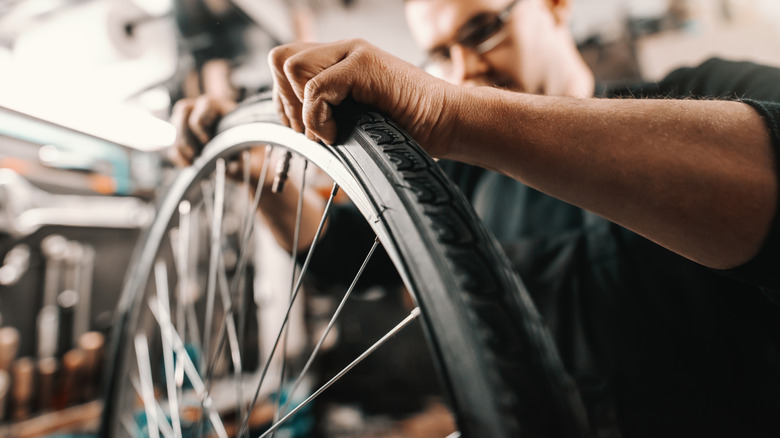 A man removing an old bicycle tire from the rim