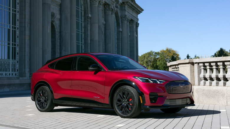 Front and side view of a red Ford Mustang Mach-E parked outdoors