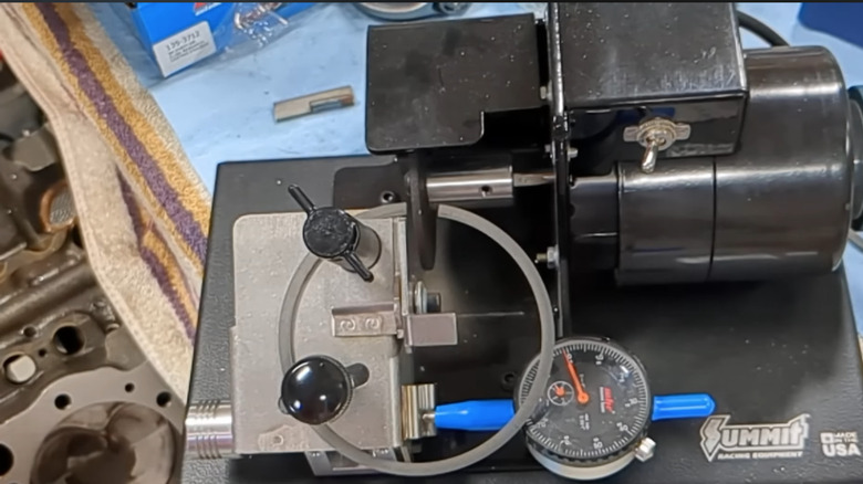 A piston ring end gap being checked using a tool