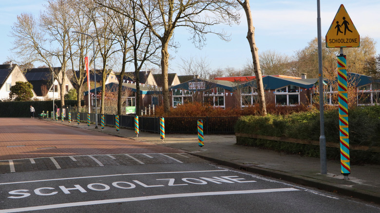 A suburban school zone setting with trees and buildings around.
