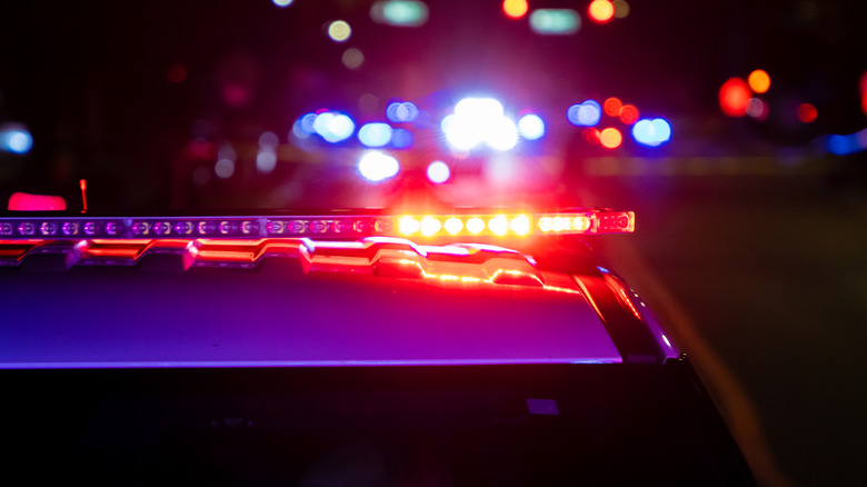 A crime scene in a city at night with blue and red police lights.